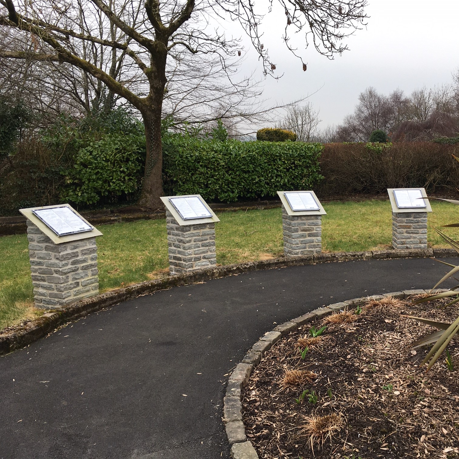 Five memory plaques on display in the memory garden, 4 seen here