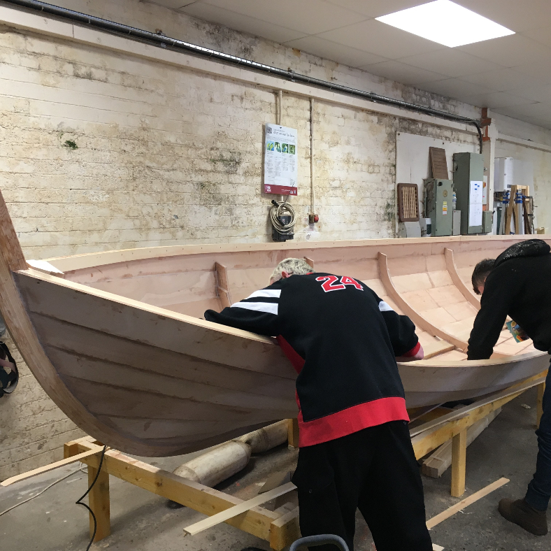 Volunteers building the skiffs